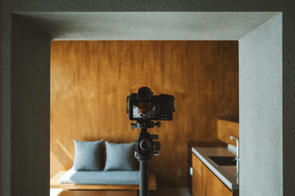 Kamera auf Stativ zeigt auf eine braune Wand Küche Sofa