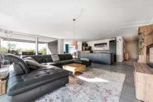 Wohnzimmer, Ledercouch, Teppich, schwarze Küche, Wohnwand, Wohnung